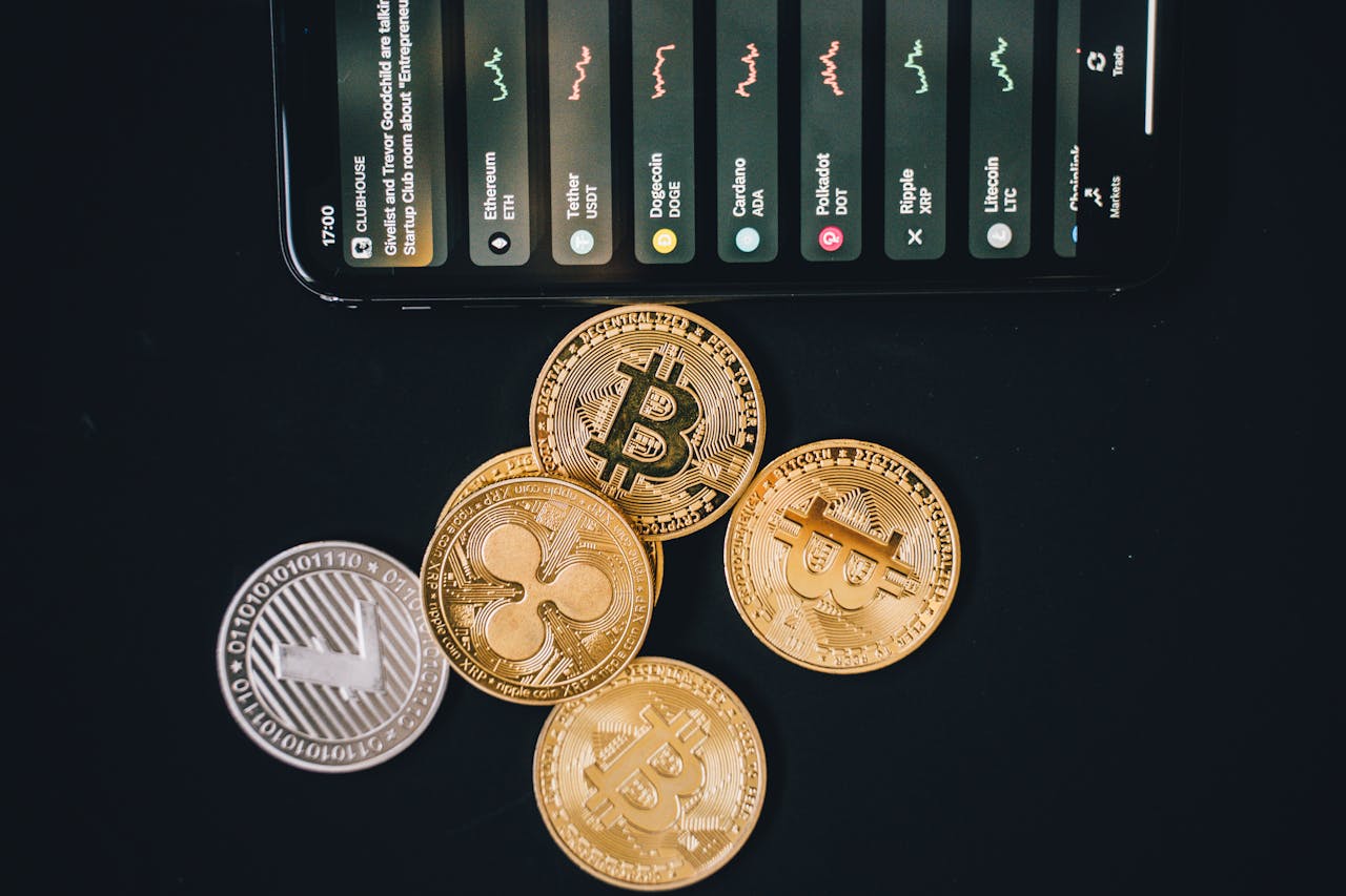 Close-up of various cryptocurrencies and a smartphone showing market trends.